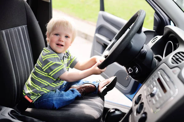 Baby boy turns the steering wheel of the car — Stock Photo, Image