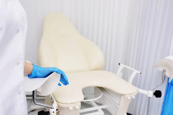 De artsen hand in een rubber hygiënische handschoen op een gynaecologische stoel. Womens raadpleging — Stockfoto