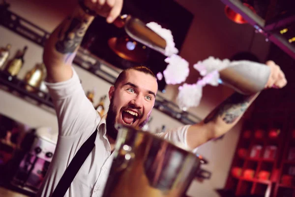 Cheerful barman smiles, screams and falls asleep in a bucket for champagne on the background of the bar. — Stock Photo, Image