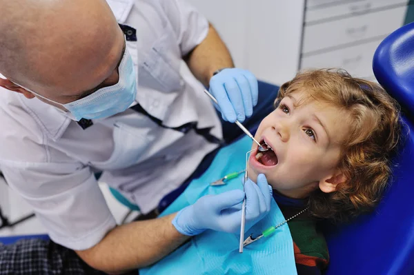 Mężczyzna dentysta bada młodego pacjenta — Zdjęcie stockowe