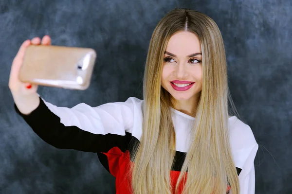 Beautiful young girl removes itself on a mobile phone — Stock Photo, Image