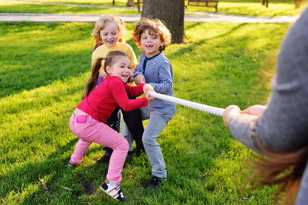 Dzieci bawią się przeciąganie liny w parku. — Zdjęcie stockowe