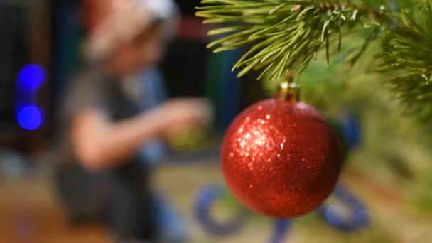 Jongen versiert kerstboom met speelgoed thuis — Stockvideo