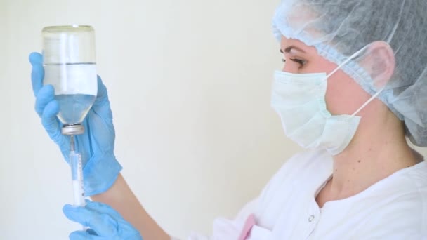 Eine junge Ärztin oder Krankenschwester füllt eine Spritze mit Flüssigkeit zur Injektion. — Stockvideo