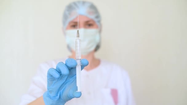 Een jonge vrouwelijke arts of verpleegkundige vult een spuit met vloeistof voor injectie. — Stockvideo