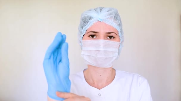 La joven doctora o enfermera se pone guantes de goma antes de examinar a un paciente enfermo o antes de la cirugía. Concepto-medicina, covid19, coronavirus, cirugía, tratamiento . — Vídeos de Stock