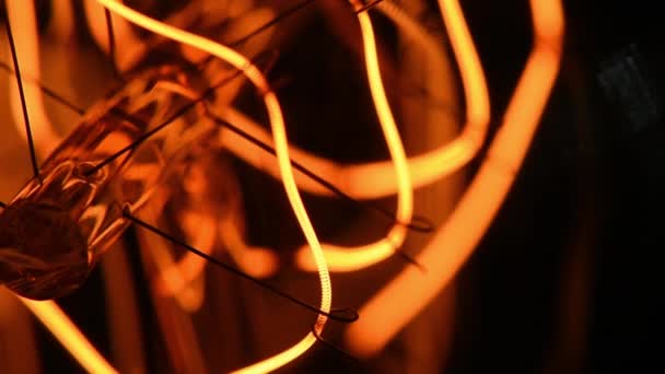 Retro-Lampe mit glühenden Wolfram-Filament Nahaufnahme auf dunklem Hintergrund. — Stockvideo