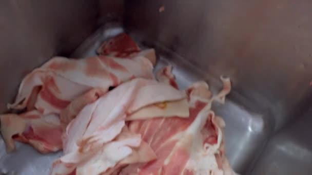 DONETSK, UKRAINE-DECEMBER 15,2018-medewerkers van het vleesverwerkingsbedrijf schuiven onverwerkte stukken vlees in een huidmachine. — Stockvideo