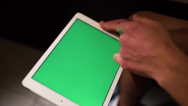 Natáčení video procesu, kde muž drží tablet v rukou a švihem doprava. Zelená obrazovka. Chlápek sedí na záchodě nebo na záchodě. — Stock video