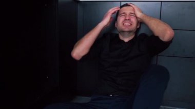 Yerde yatan sinirli genç adam sadece baş ağrısı ya da depresyondan muzdarip. Ellerinizi başınızın üstüne koyun. Zihinsel sorunlar hakkında düzensizlik.
