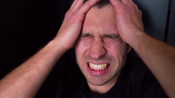 Close-up portret van de jongeman schreeuwen en schreeuwen van hoofdpijn en pijn. Lijden aan depressie en slecht humeur. Een gebroken man, boos en boos. Crisis en ongeluk. — Stockvideo