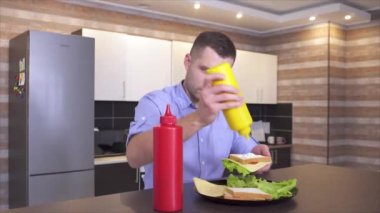 Mutfakta sandviçi bitiren genç adamın videosunu kaydediyorum. Biraz hardal ekleyip üstüne de peynir ekliyorum. Yemeği bölmeye hazırım..