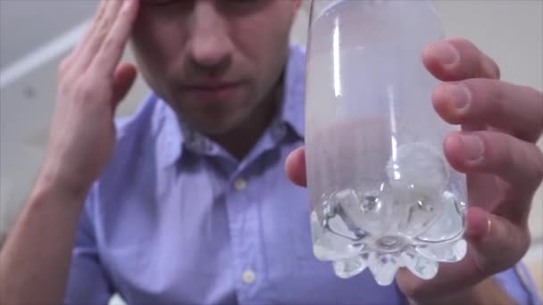 Junger Mann mit Kopfschmerzen oder Kater hält Glas mit Wasser und seelenvoller Tablette in der Hand. Den Kopf massieren. Warten auf Medikamente. — Stockvideo