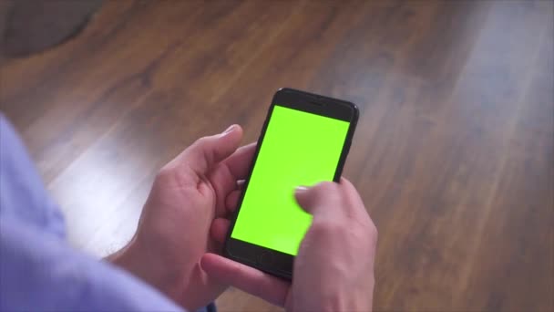 Manos de hombre sosteniendo el teléfono inteligente y usarlo. Pantalla verde en el dispositivo. Escribir en el teclado electrónico y deslizar hacia la derecha, arriba y abajo . — Vídeo de stock