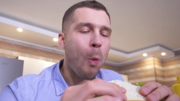 Very slow video of guybiting big piece of homemade sandwich and chewing it. Enjoy eating it. Bite one more piece and divour meal. — Stock Video