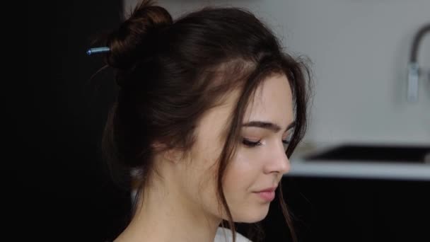 Young woman in kitchen during quarantine.Camera moves down. Video process of girl typing on keyboard of laptop. Work remote at home. Concentrated woman. — Stock Video