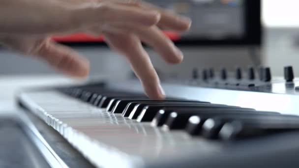 Jovem no estúdio de gravação de som. Mão direita tocando no teclado. Movimento lento de aprendizagem não profissional e estudar para brincar . — Vídeo de Stock