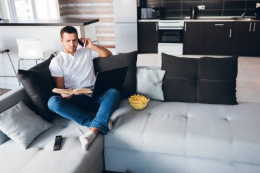 Genç adam kendi dairesinde televizyon izliyor. Aynı anda hem kitap okuyup hem de telefonla konuşan ciddi bir konsantre adam. Dizlerinin üstüne çök. Çalışıyorum ya da çalışıyorum. Uzaktan ofis dışı.