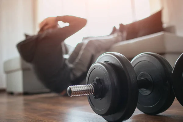 Genç, sıradan bir adam spor olsun diye evine gidiyor. Acemi ya da birinci sınıf öğrencisi evinde egzersiz yaparken görüntüsünü kes. Dambıllar yerde yatıyordu. Daha iyi görünmeye çalışıyorum..