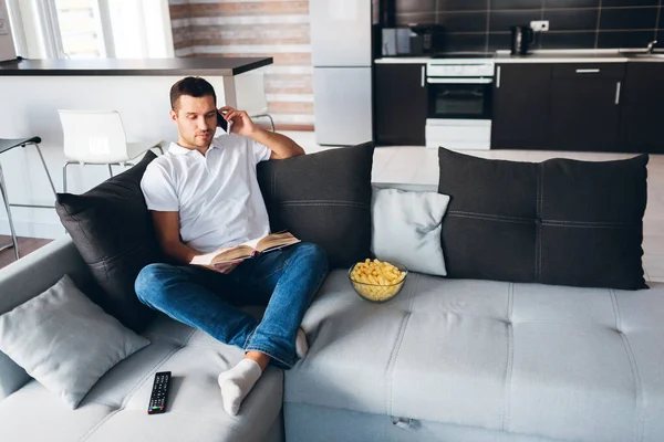 Genç adam kendi dairesinde televizyon izliyor. Aynı anda hem kitap oku hem de telefonda konuş. İş görüşmesi. Çalışmak ya da evden çalışmak. Ofis işi bitti. Kanepede yalnız başına..