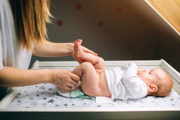 Anne ve yeni doğan çocuk kreşte. Annem çocuk için egzersiz yapıyor. Displazi ve kas tonu