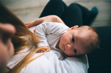 Yeni doğmuş bir bebeğin portresi. Anne kucağında bir çocuk tutuyor. Yaşamın ilk yılı. Bakım ve bakım