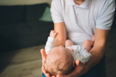 Yeni doğmuş bir bebeğin portresi. Babası kucağında bir çocuk tutuyor. Yaşamın ilk yılı. Bakım ve sağlık