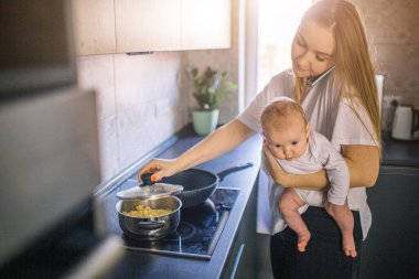 Anne bebeğini kollarında tutuyor. Mutfakta da aşçılar var. Annem telefonda konuşuyor ve çok meşgul. Çokluişlevlilik kavramı.