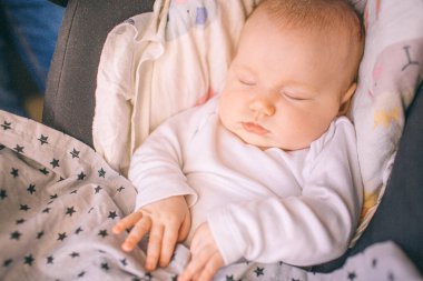 Toddler evde uyuyor. Bakım ve sağlık. Yaşamın ilk yılı. Küçük bir oğlan ya da kız bebek arabasında. Yakın plan..