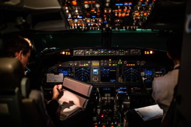 Kiev Kyiv Ukrayna - Aralık 2019: Uçak pilotları iş başında. Kokpite doğru bakın. Uçuş aletleri ve ekipmanları. Uçak uçuş güvertesi. Uçak kokpitinden gökdelenlere ve şehir merkezlerine bakın.