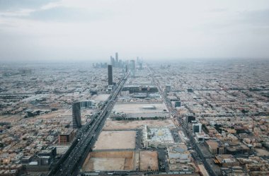 Skyline view at Riyadh in direction of King Abdullah Financial District from the top of Riyadh Kingdom tower in foggy cloudy day clipart