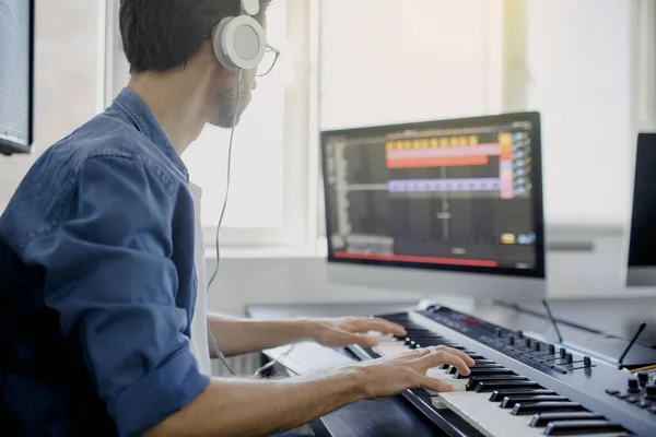 Componist handen op piano toetsen in opnamestudio. muziek productie technologie, de mens werkt aan piano en computer toetsenbord op bureau. — Stockfoto