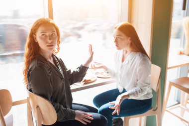 Kadın model bir meslektaşıyla durur ve arkasını döner. Genç kadın üzgün ve aynı fikirde değil.