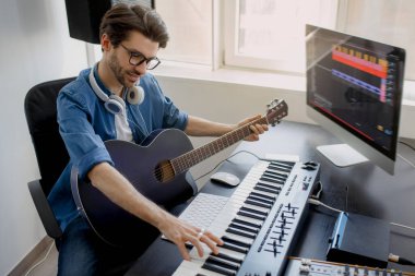 Adam gitar çalıyor ve kendi projesinde elektronik soundtrack veya pist üretiyor. Dijital kayıt stüdyosunda Midi piyano ve ses ekipmanları üzerine şarkı besteleyen erkek müzik düzenleyicisi.