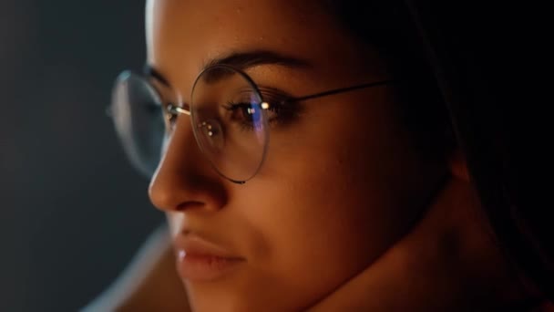 Fiatal nő otthon a karantén alatt. Közelkép és vágott kilátás komoly nyugodt koncentrált lány szemüvegben videó nézés. Tükröződés. — Stock videók