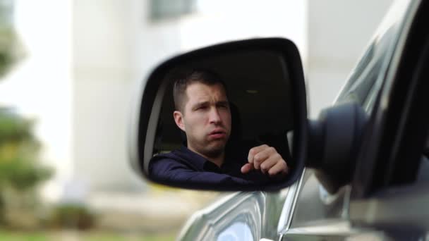 Jongeman in de auto. Een uitzicht in zijspiegel van zakenman voorzichtig hard. Bedek de mond met vuist. Coronavirussymptomen. Langzame beweging. — Stockvideo