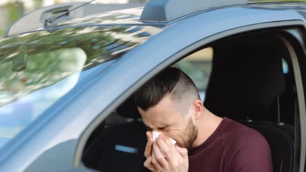 Jongeman in de auto. Zieke hipster niest in wit weefsel en lijdt. Veeg neus en ogen van tranen. Coronavirussymptomen. Langzame beweging. — Stockvideo