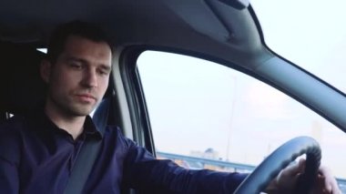 Arabanın içindeki genç adam. Şoför ön koltukta tek başına oturuyor. Konsantre ve ciddi bir iş adamı dikkatli sürüyor. Yola bakıyorum..