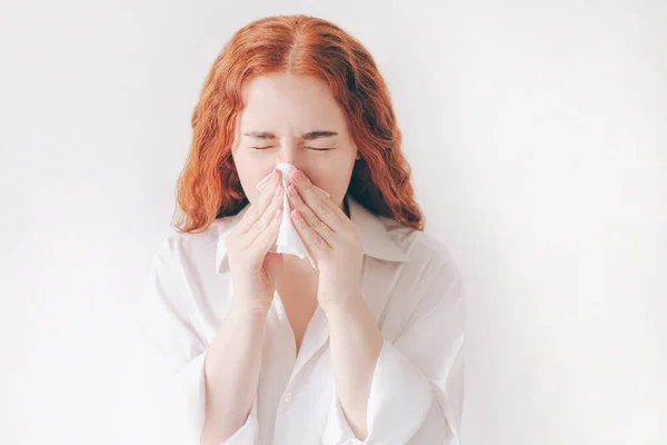 Una joven con pañuelo. La chica enferma tiene secreción nasal. Modelo femenino hace una cura para el resfriado común aislado sobre fondo blanco — Foto de Stock