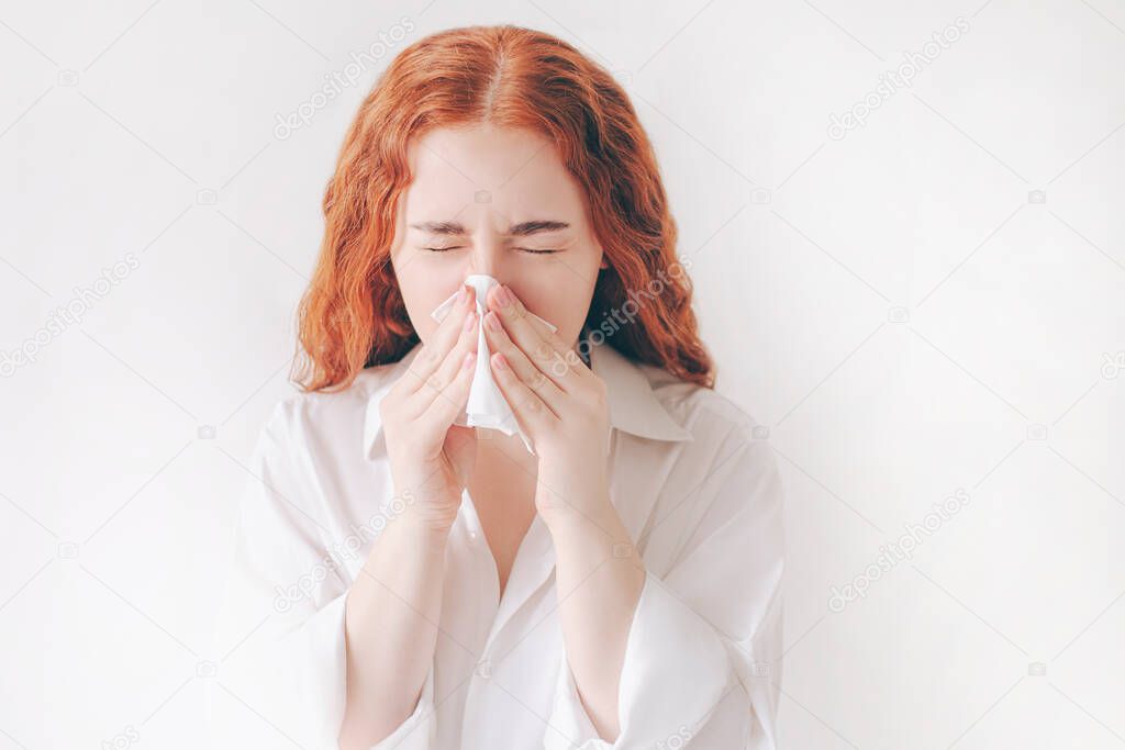 young woman with handkerchief. Sick girl has runny nose. Female model makes a cure for the common cold isolated on white background background