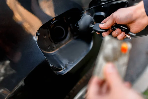 Homme avec carte de crédit ouvrant le réservoir de carburant de sa nouvelle voiture. Calcul sans espèces de l'argent. Carburant, essence, diesel, concept de gaz — Photo