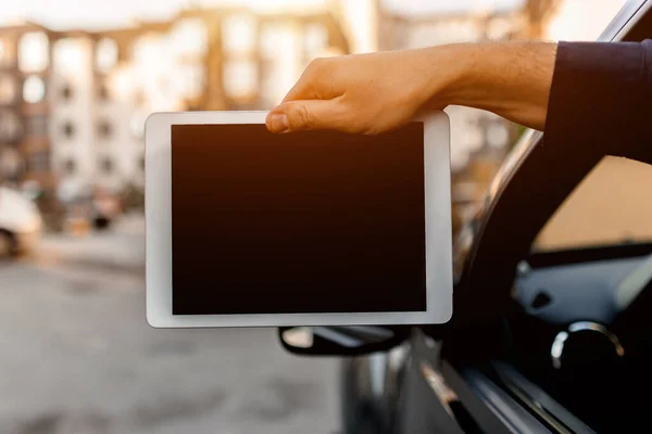 Um driver mostra um tablet pc tela close-up na câmera. Espaço vazio para o seu texto ou gráficos . — Fotografia de Stock