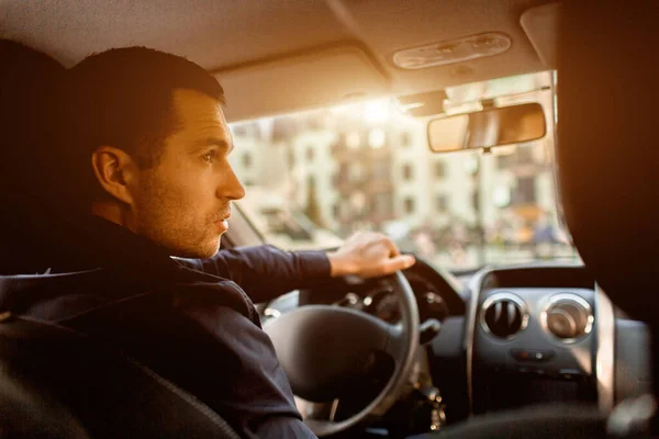 Un uomo si siede in una cabina e guarda la strada. Un tassista in macchina. Concetto di trasporto . — Foto Stock