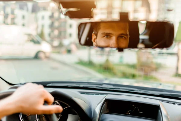 Um homem olha pela janela de visão traseira. No carro dele. Conceito de transporte — Fotografia de Stock