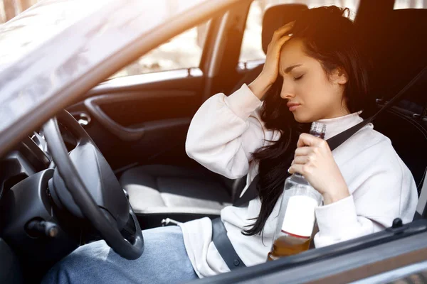 Пьет за рулем. Пьяная женщина водит машину. Жизнь угрожает выпивкой и вождением автомобиля . — стоковое фото