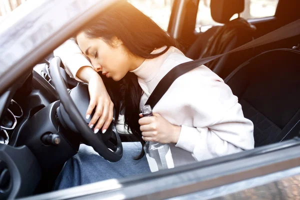 A beber ao volante. Uma mulher bêbada conduz um carro. Vida ameaçando beber álcool e dirigir um carro . — Fotografia de Stock