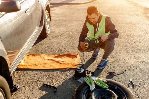 Worker or driver tired of repairing a car on the side of the road