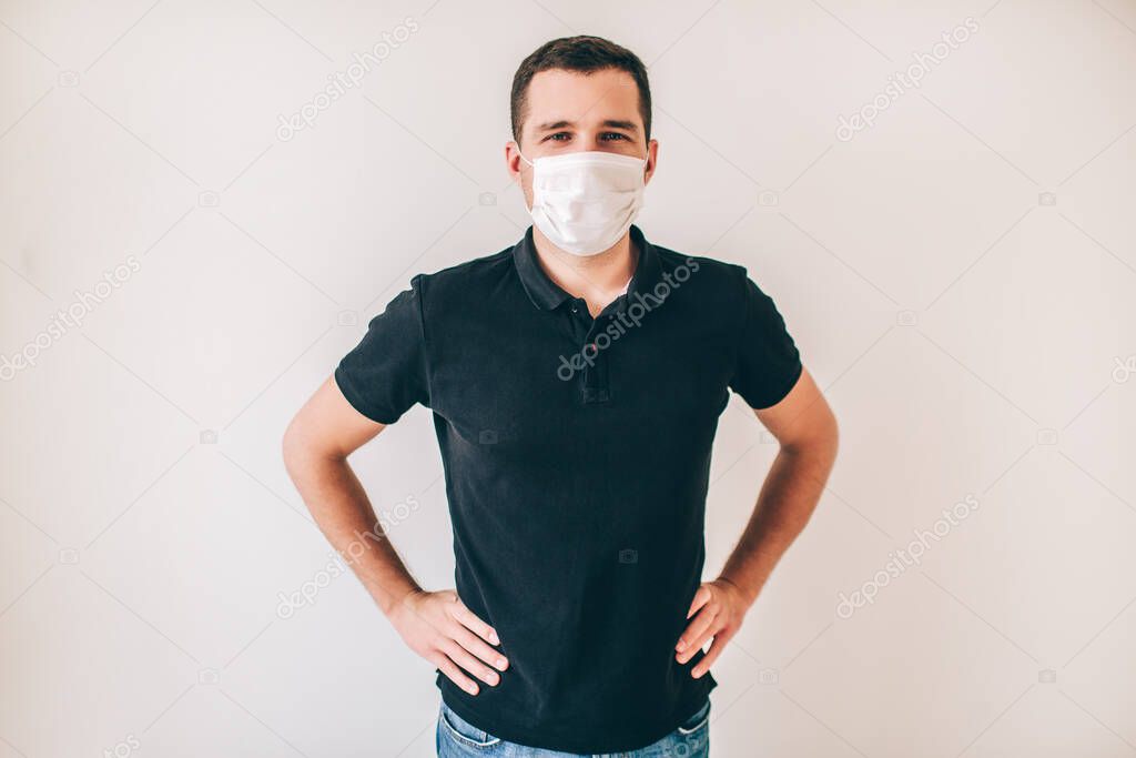 Young sick man isolated over background. Guy in black shirt wear medical protection mask. Take care about health and wellness. Posing on camera.