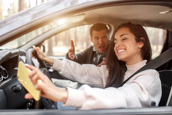 Vezetői tanfolyam. Egy fiatal nő megtanul autót vezetni. Az oktatójának vagy a barátjának nem tetszik, ahogy autót vezet. De a lány elégedett magával, és nem hallgat a srácra.. — Stock Fotó