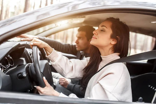 Istruzioni di guida. Una giovane donna impara a guidare un'auto per la prima volta. Il suo istruttore o fidanzato la aiuta e le insegna — Foto Stock